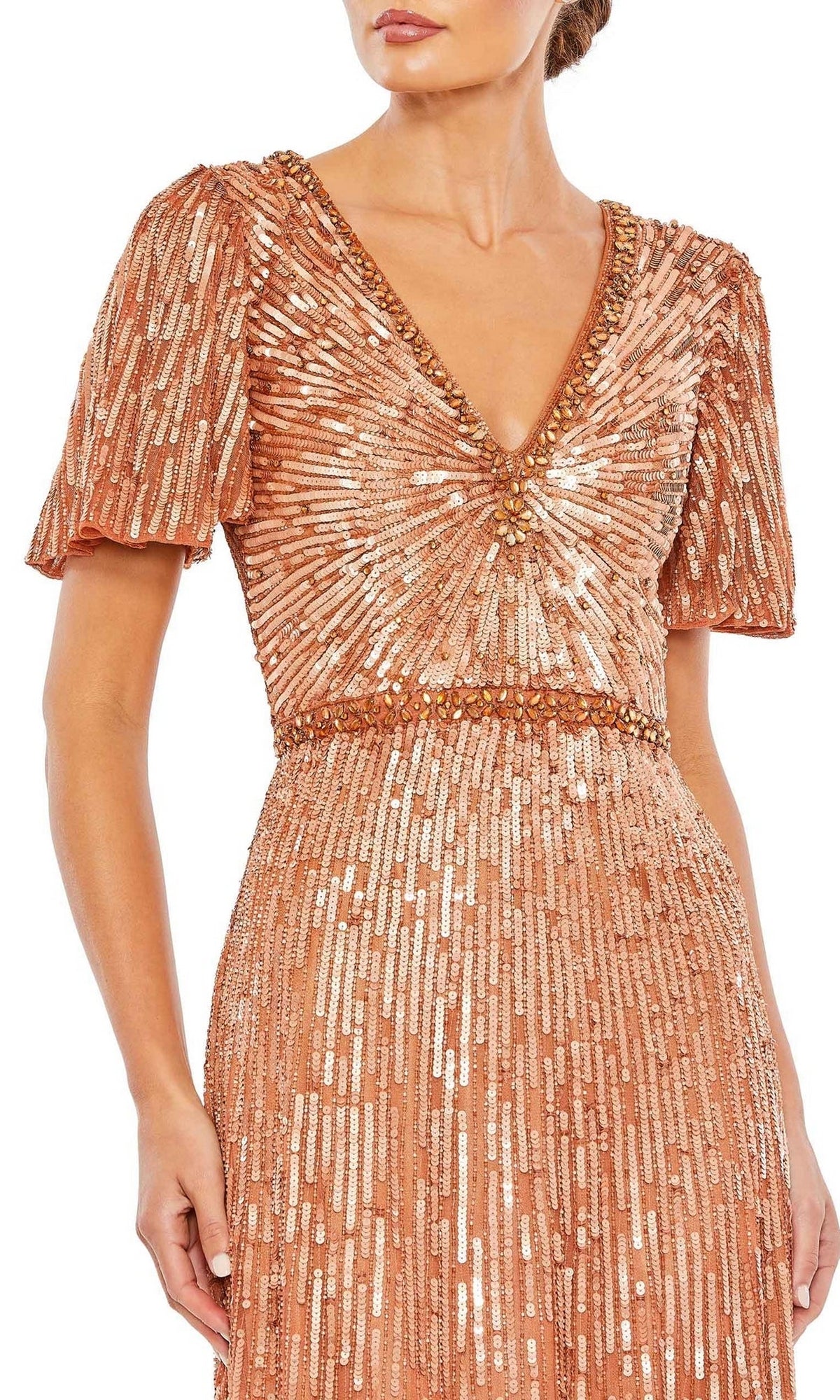 A woman wearing the Mac Duggal Long Formal Dress 5538, a peach V-neck gown with short sleeves, beaded waist, and gold sequins in vertical and radiating patterns.